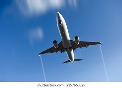 Twin-engine Commercial Aircraft Landing As Seen From Below. The Sky Is In Blur Motion Due To The Speed Of The Aircraft.