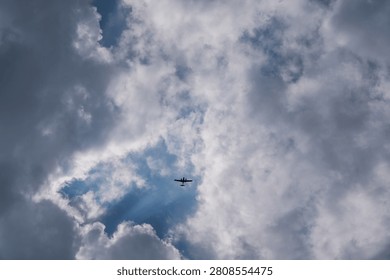 A twin-engine light aircraft flying through a cloudy sky. Aviation scene featuring a small private airplane above the clouds, representing general aviation, flight training, air travel and aircraft technology.