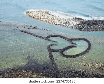 Twin-Heart Fish Trap is a stone fishing weir located on the  Penghu County, Taiwan. It is a well-preserved ancient fish trap made by stacking stones to form a trap that resembles a flying heart. - Powered by Shutterstock