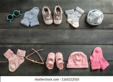 Twins babies shower concept. Baby boy and girl shoes and socks on blue wooden background, copy space, top view
