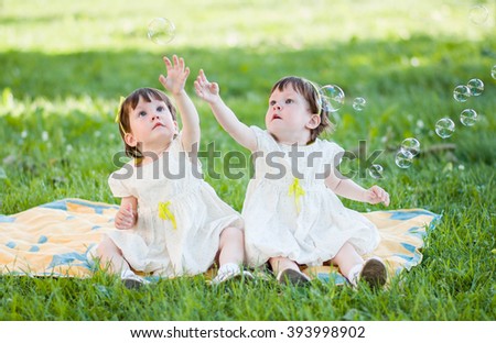 Similar – A boy and a girl in toddlerhood are standing on a log in summer clothes