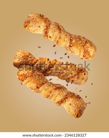 twist puff pastry with sesame seeds on a beige background, flying food