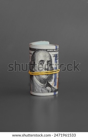 twisted bundle 100 dollar bills, rolled bundle of hundred-dollar bills on a gray background, unaccounted cash, money loves silence, illicit income  vertical shot