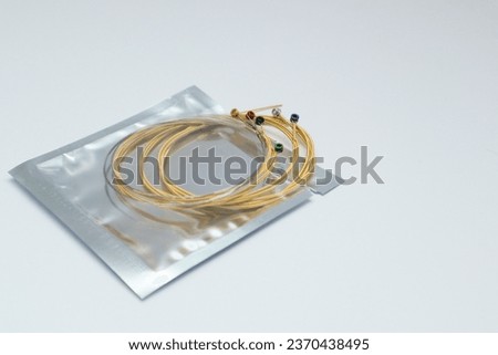 Twisted new guitar strings on white background. Brand new acoustic guitar strings. Place for text.