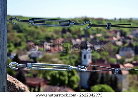 twister wire steel cable railing. galvanized metal tension turnbuckle. closeup view. connection and tightening hardware device. rail guard detail. modern twisted wire rope design