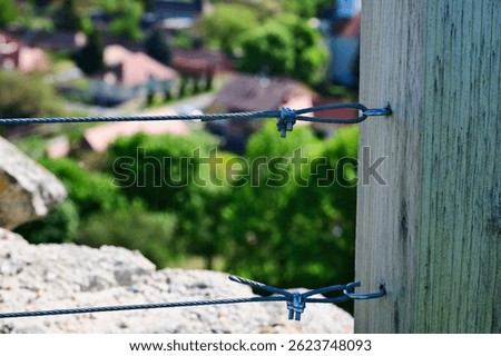twister wire steel cable railing. galvanized metal tension turnbuckle. closeup view. connection and tightening hardware device. rail guard detail. modern twisted wire rope design