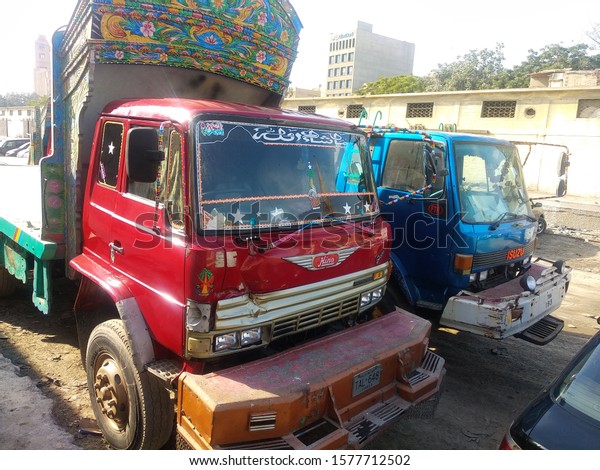 Two 10 wheeler flatbed truck from front \
 ,  which\
are decorated with traditional truck art  at merewether tower-\
karachi pakistan - Dec 2019