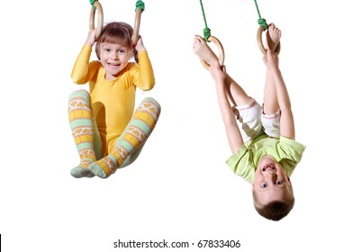 two 4 year old kid hanging on gymnastic rings