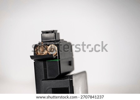 Two AA batteries showing signs of corrosion, installed in a camera flash.