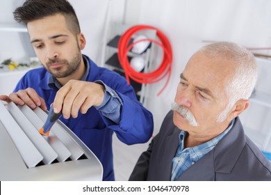 Two Ac Technicians Repairing An Industrial Air Conditioning Compressor