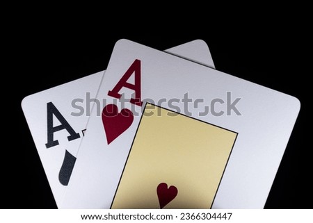 Two aces on the black background. Aces in the dark room. Combination of two aces close-up. Ace of Spades and Ace of Hearts