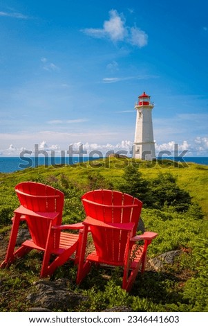 Two Adirondack benches or Muskoka chairs with a lighthouse in Louisbourg on Cape Breton, Nova Scotia
