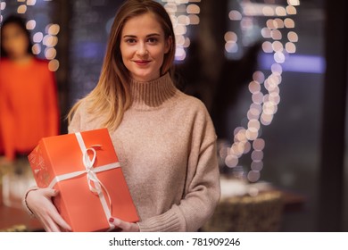 Two Adolescent Women Sitting In A Fancy Restourant, Going Through The Menue, While Drinking Some Red Wine, Talking, Gossiping And Unwrapping Their Christmass Presents And Looking At Their Phones. 