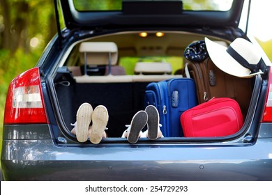 Two adorable little sisters sitting in a car just before leaving for a car vacation with their parents - Powered by Shutterstock