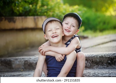 Two Adorable  Sibling Boys Hugging And Having Fun Outdoors. Cute Friends Playing Together On Sunny Warm Summer Day. Brother Love.