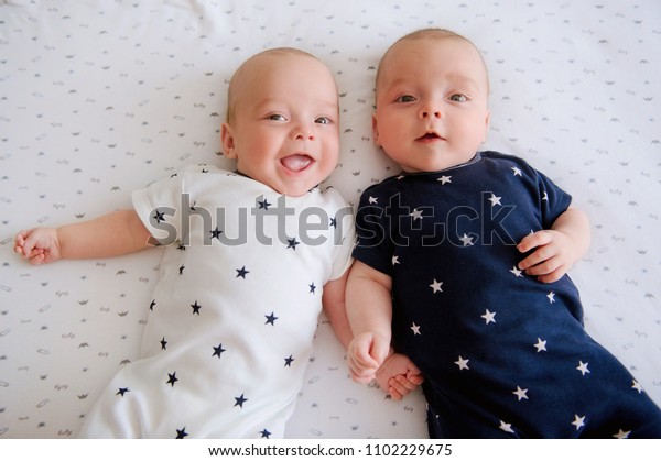かわいい双子の赤ちゃんが2人とも幸せそうに微笑んでいる 前向きなライフスタイルのコンセプト 幸せな子供時代 上から表示 の写真素材 今すぐ編集