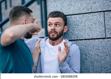 Two adult bearded men are fighting in the street. Conflict, bullying, robbery. - Shutterstock ID 1805088298