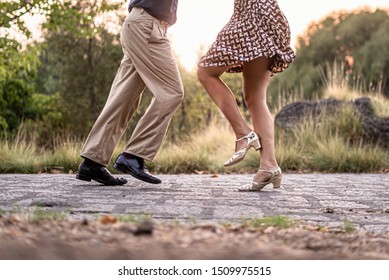 Two adult dancers feet dancing swing music outdoors in the park - unrecognizable people