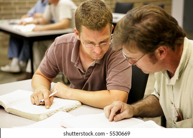 Two Adult Education Students Studying Together In Class.