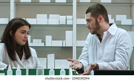 Two adult pharmacists having conflict, discussing problems at pharmacy