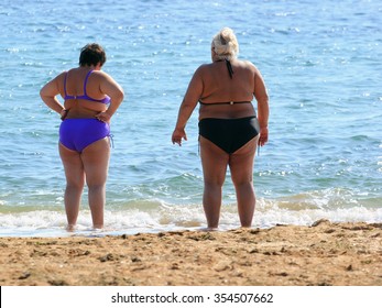 Two adult plus size women on a beach.