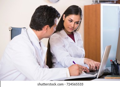 Two Adult Professional Doctors Brainstorming And Sharing Information In Clinic