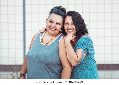 Two Adult Twin Sisters Hugging. Different Styles