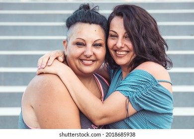 Two Adult Twin Sisters Hugging. Different Styles