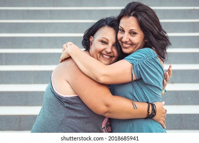 Two Adult Twin Sisters Hugging. Different Styles