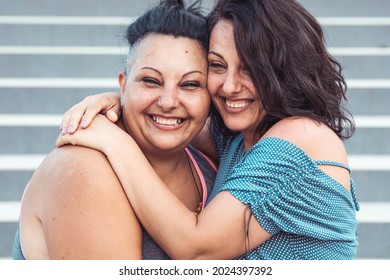 Two Adult Twin Sisters Hugging. Different Styles