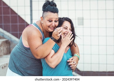 Two Adult Twin Sisters Hugging And Laughing. Different Styles