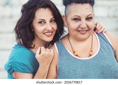 Two Adult Twin Sisters Hugging. Different Styles