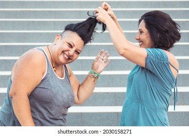 Two Adult Twin Sisters Playing With Each Other