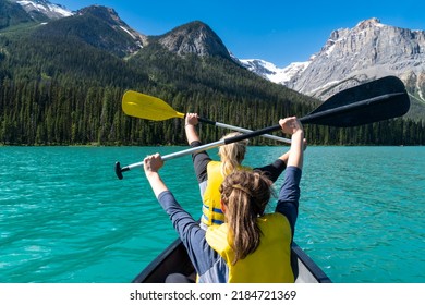 Two adult woman paddle on a canoe on Emerald Lake in Yoho National Park in British Columbia Canada - Powered by Shutterstock