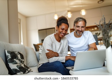 Two Adults, Smiling, Browsing Something Online.