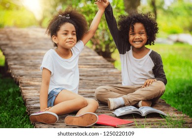 Two African American Afro Children Together In The Garden. Happy Young Little Boy And Girl In The Park. 