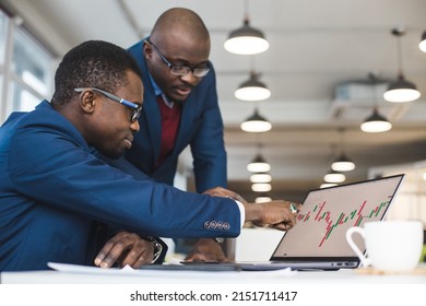 Two African American Business Partners Are Working On A Laptop Studying Stock Market Charts And Technical Analysis. Training In Investment And Analysis Of Macroeconomic And Financial Indicators