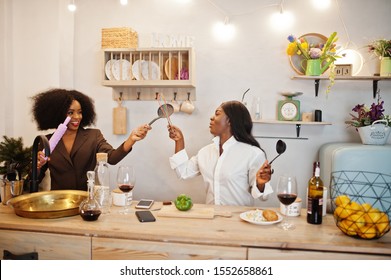 Two African American Female Friends Women Spending Time At Kitchen With Wine. Black Girlfriends  Relaxing At Home. 