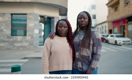 Two African American Friends With Serious Expression Hugging Each Other Standing At Street