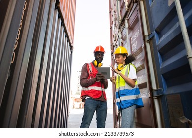 Two African american male and female worker using tablet and checking control loading freight containers from Cargo freight ship for import export. - Powered by Shutterstock