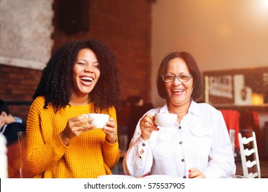 Two African american woman drinking coffee.  - Powered by Shutterstock