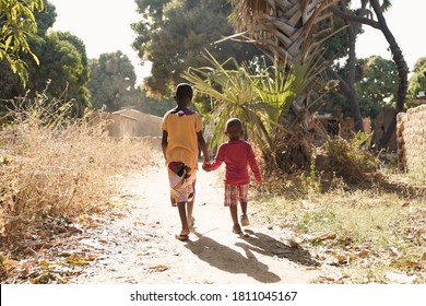 Two African Children Walk Down Natural Road In African Village