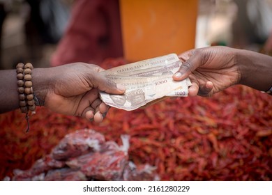 Two African Hands Of A Seller And Buyer Exchanging Money, Cash, Currency Or Naira Notes In A Market Place During Transaction