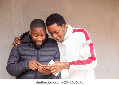 two african men excited about they saw on their cell phone