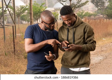 Two African Men Looking Into Their Phones