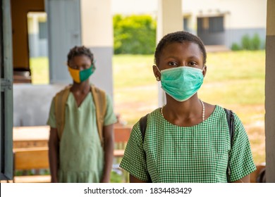 two african school kids wearing face masks and physically distancing themselves