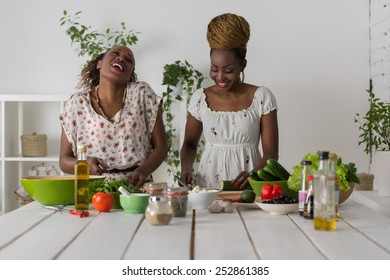 Two African Women Cooking In Kitchen Making Healthy Food Salad With Vegetables