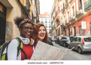 Two Afro American Girls Traveling Together. Two Friend Girls Using A Map In Europe. Latin American Girls On Holidays.Travel Concept.