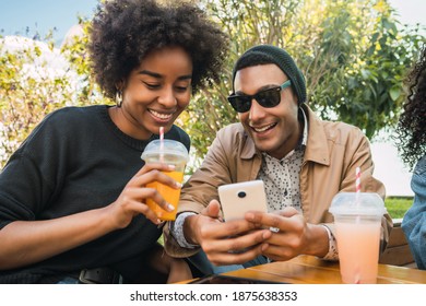 Two Afro friends using their mobile phone.