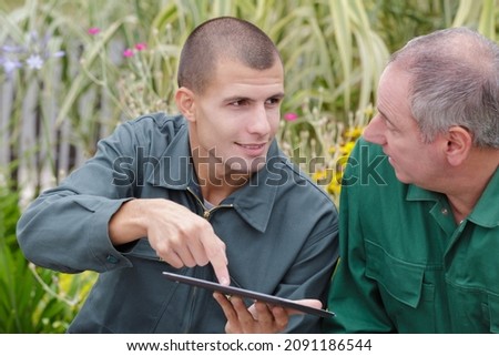 two agricultural engineers analyze data with tablet computer